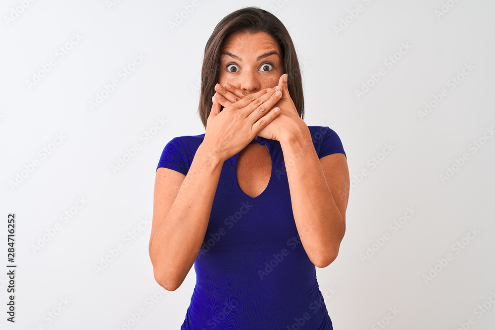 Young beautiful woman wearing blue elegant t-shirt standing over isolated white background shocked covering mouth with hands for mistake. Secret concept. Young beautiful woman wearing blue elegant t-shirt standing over isolated white background shocked covering mouth with hands for mistake. Secret concept.