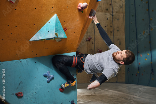 Quadro su tela Physically handicapped sportsman starts his rock climbing training in the indoor settings, dreams to pass pre-qualification on bouldering competition for people with physical disabilities