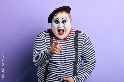 Foto laughing crazy plump mime with wide open mouth points with finger at you, happiness, emotion and feeling
