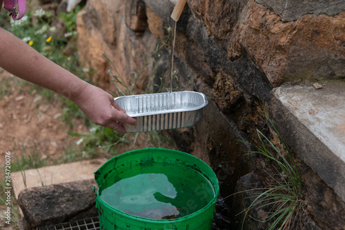 Obraz na płótnie mountain landscape with water tap and green bucket w salonie