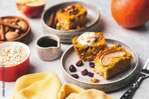 Pumpkin spice cake with walnuts, dried cranberry and maple syrup on plate. Deliciois moist cake. Autumn comfort food photo