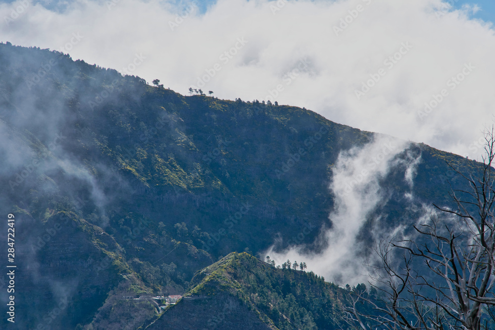 View from the hiking trail at the Boca da Corrida belvedere on the Encumeada pass on Madeira Island, Portugal in summer, View to the village of Curral das Freiras View from the hiking trail at the Boca da Corrida belvedere on the Encumeada pass on Madeira Island, Portugal in summer, View to the village of Curral das Freiras