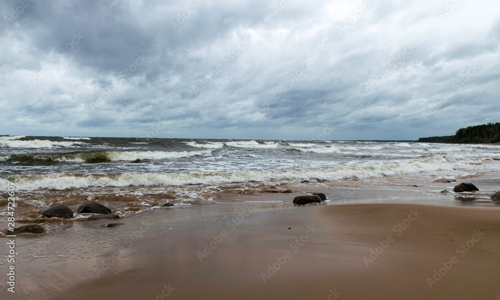 Fototapeta premium beautiful waves going to the coast, stormy sea with thunder clouds over,