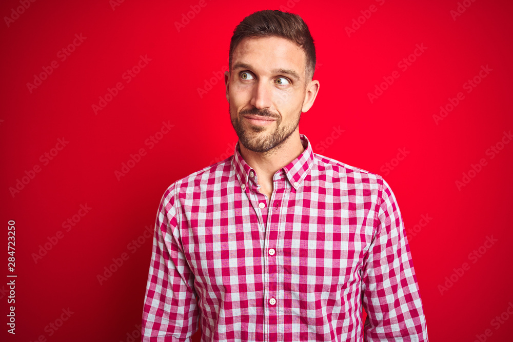 Young handsome man over red isolated background smiling looking to the side and staring away thinking. Young handsome man over red isolated background smiling looking to the side and staring away thinking.