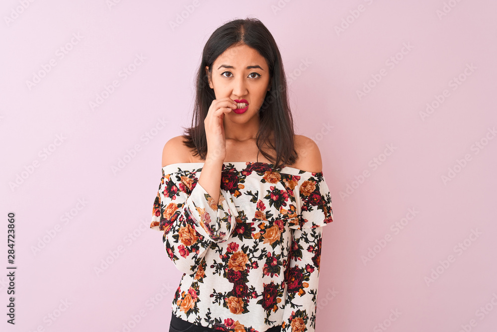 Young chinese woman wearing floral t-shirt standing over isolated pink background looking stressed and nervous with hands on mouth biting nails. Anxiety problem. Young chinese woman wearing floral t-shirt standing over isolated pink background looking stressed and nervous with hands on mouth biting nails. Anxiety problem.