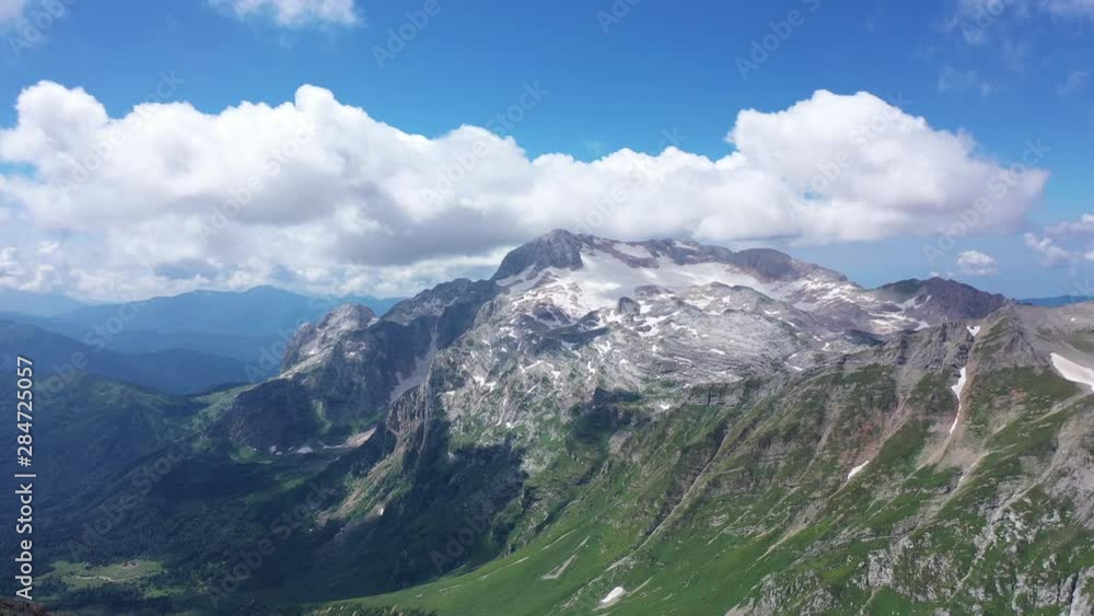 Aerial shot of a mountain ridge against rocky cliffs, glacier and snowy peaks. Amazing aerial view of a mountain landscape. Aerial shot of a mountain ridge against rocky cliffs, glacier and snowy peaks. Amazing aerial view of a mountain landscape.
