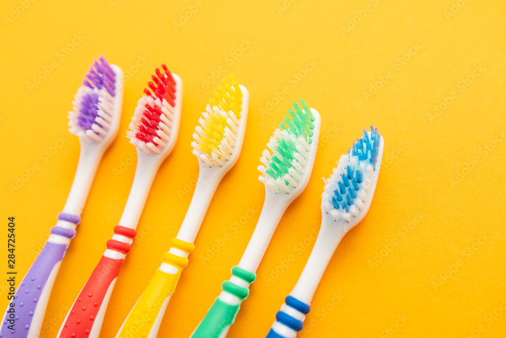 set of plastic toothbrushes on yellow background set of plastic toothbrushes on yellow background