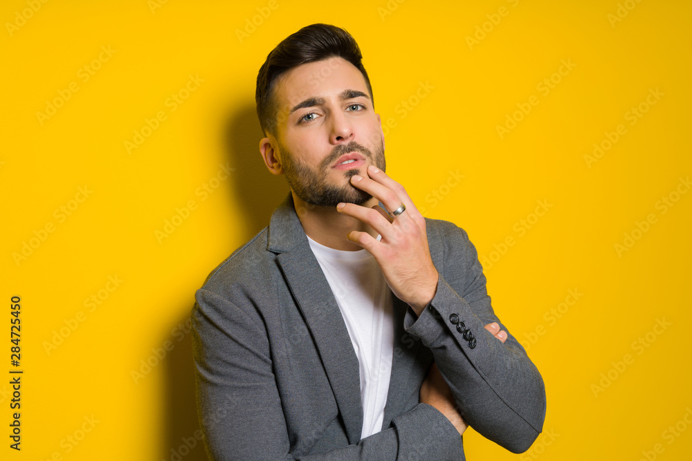 Young handsome man possing and modeling over yellow isolated background Young handsome man possing and modeling over yellow isolated background