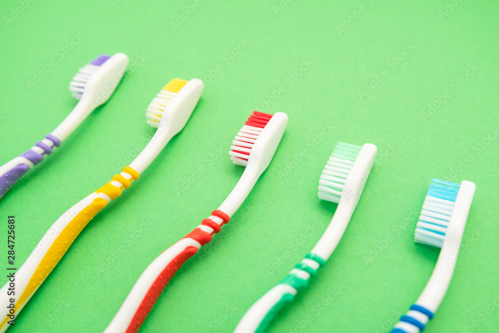 set of plastic toothbrushes on green background set of plastic toothbrushes on green background