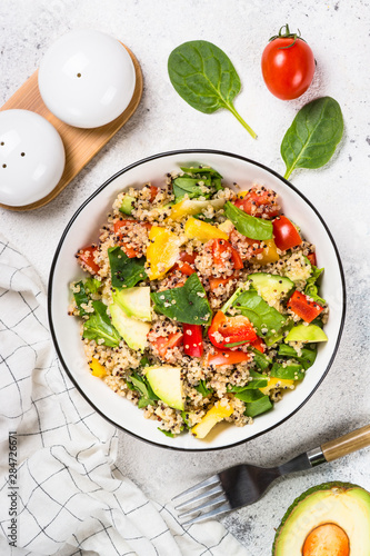 Quinoa salad with fresh vegetables on white.