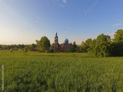 Green grass  blue sky  and a Church of our lady mother of Kazan in Smolyarova in the distance. Tatarstan  Russia