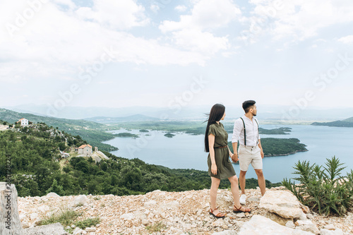 A young couple admires the beautiful landscape in Montenegro.