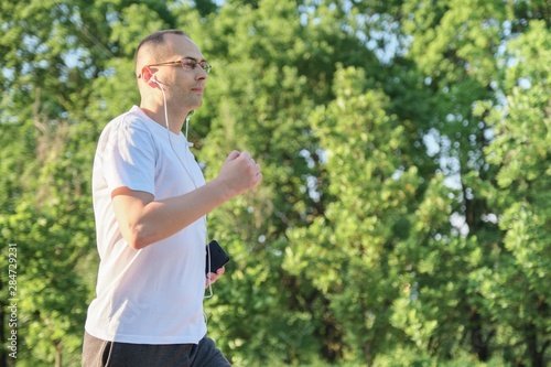 Middle-aged man running in the park, active healthy lifestyle
