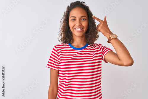 Young brazilian woman wearing red striped t-shirt standing over isolated white background Smiling pointing to head with one finger, great idea or thought, good memory © Krakenimages.com