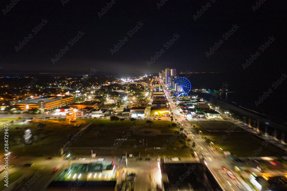 Motion blur flying approach Myrtle Beach at night city lights