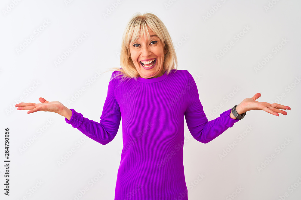 Middle age woman wearing purple t-shirt standing over isolated white background celebrating crazy and amazed for success with arms raised and open eyes screaming excited. Winner concept Middle age woman wearing purple t-shirt standing over isolated white background celebrating crazy and amazed for success with arms raised and open eyes screaming excited. Winner concept