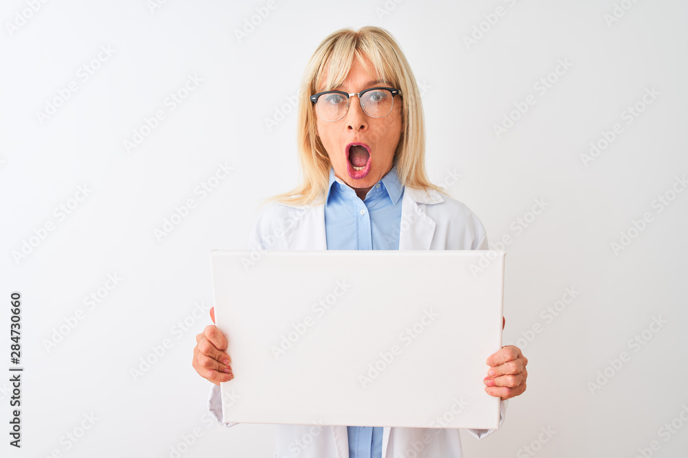 Middle age scientist woman wearing glasses holding banner over isolated white background scared in shock with a surprise face, afraid and excited with fear expression Middle age scientist woman wearing glasses holding banner over isolated white background scared in shock with a surprise face, afraid and excited with fear expression