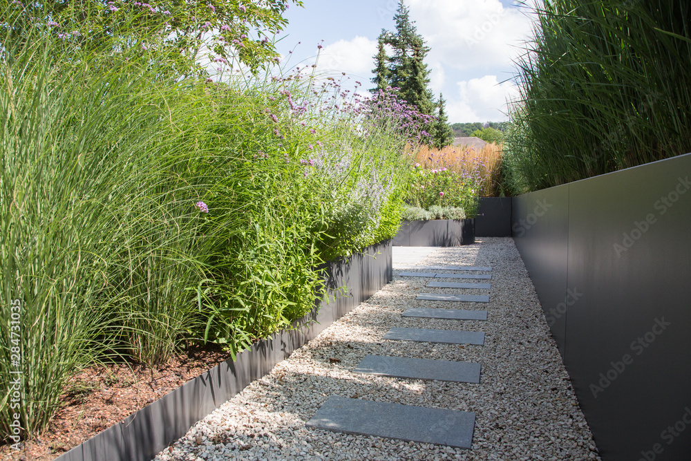 Moderne Garten und Terrassengestaltung im Materialmix Gehweg und