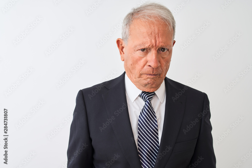 Senior grey-haired businessman wearing suit standing over isolated white background skeptic and nervous, frowning upset because of problem. Negative person. Senior grey-haired businessman wearing suit standing over isolated white background skeptic and nervous, frowning upset because of problem. Negative person.