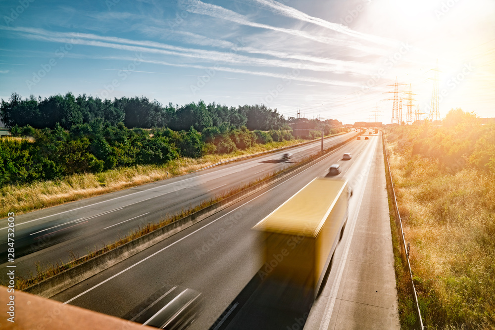 Fototapeta premium Lots of Trucks and cars on a Highway - transportation concept