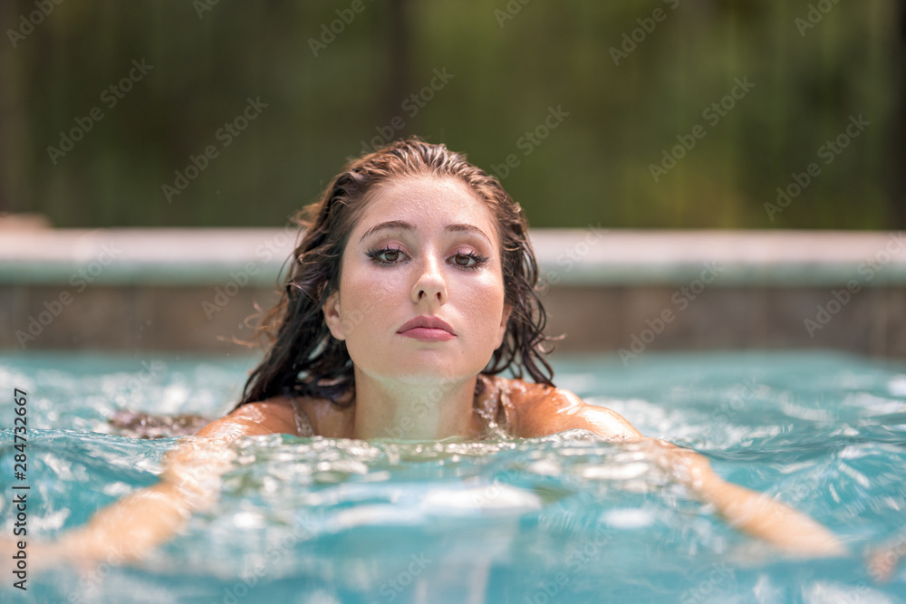 Woman swimming approaching camera in the pool