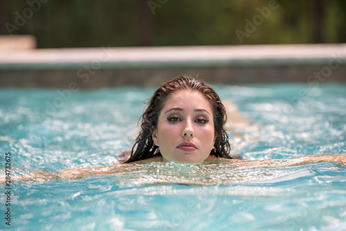 Beautiful woman swimming in a pool blurry background