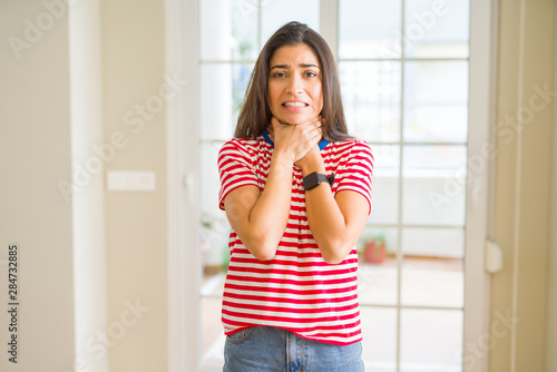 Young beautiful woman wearing casual t-shirt shouting and suffocate because painful strangle. Health problem. Asphyxiate and suicide concept. Free Download Young beautiful woman wearing casual t-shirt shouting and suffocate because painful strangle. Health problem. Asphyxiate and suicide concept. - GFXLoad