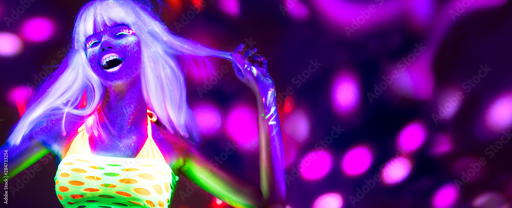 Neon Woman dancing. Fashion model woman in neon light, portrait of beautiful model with fluorescent make-up, Art design of female disco dancer posing in UV, colorful make up. On bright background Neon Woman dancing. Fashion model woman in neon light, portrait of beautiful model with fluorescent make-up, Art design of female disco dancer posing in UV, colorful make up. On bright background