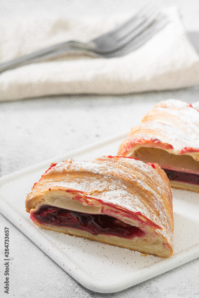Strudel with cherry white Board on light background