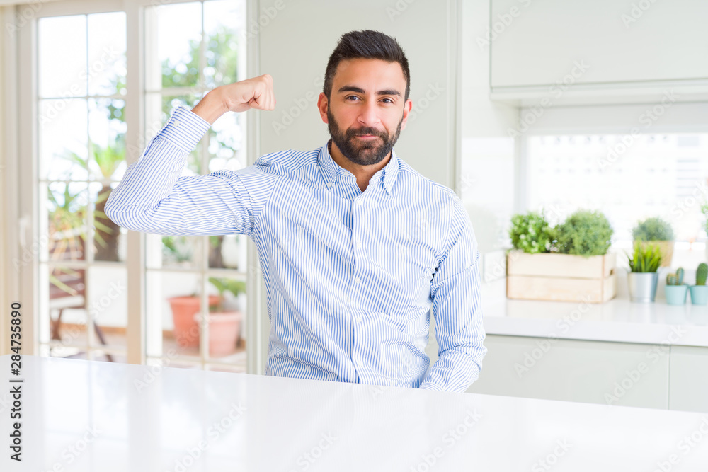 Fototapeta premium Handsome hispanic business man Strong person showing arm muscle, confident and proud of power