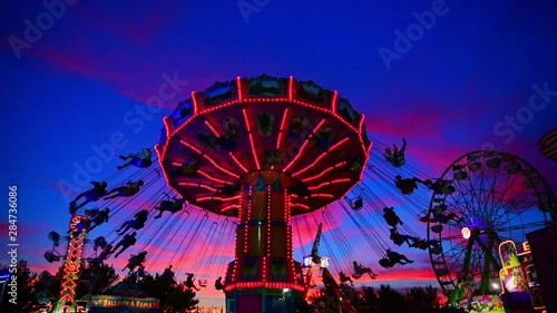 Swing Carousel spins in the nigh sky as the sun goes down creating the perfect sunset