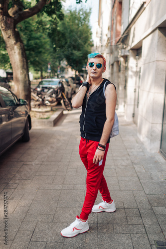 Sportive homosexual man with makeup posing with passion on street