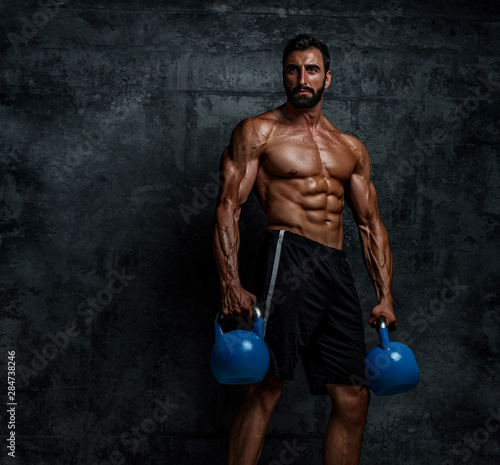 Strong Muscular Men Exercise With Kettlebells as part of His Cross Workout