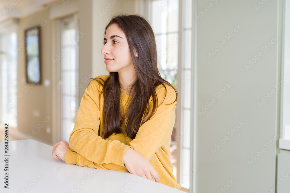 Beautiful young woman wearing yellow sweater looking to side, relax profile pose with natural face with confident smile. Beautiful young woman wearing yellow sweater looking to side, relax profile pose with natural face with confident smile.