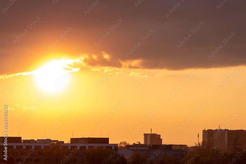 Cityscape and sunset with silhouettes of houses.
