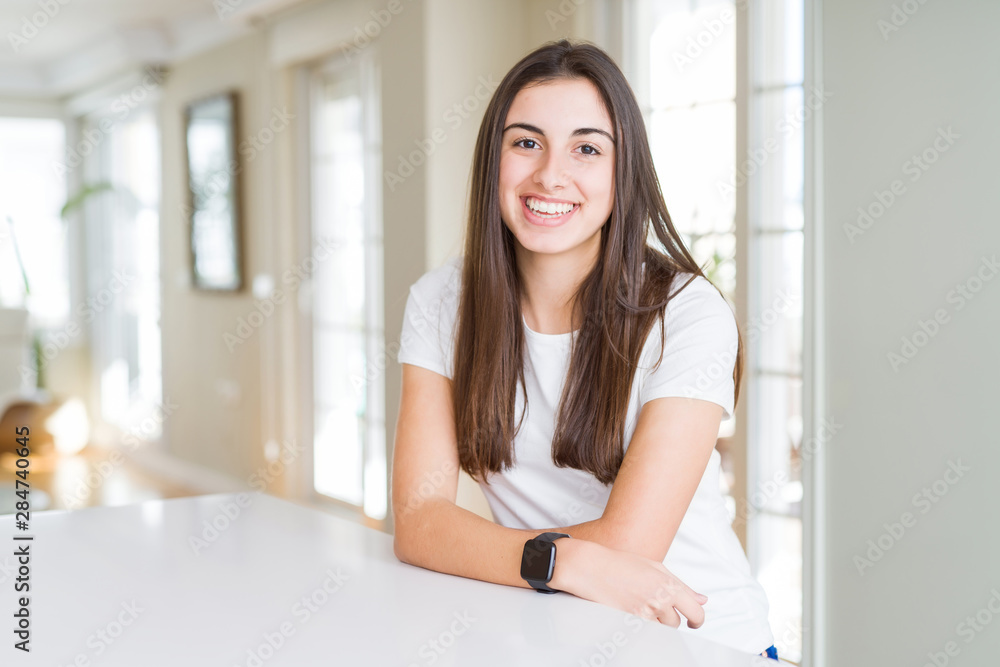Beautiful young woman wearing casual white t-shirt with a happy and cool smile on face. Lucky person. Beautiful young woman wearing casual white t-shirt with a happy and cool smile on face. Lucky person.