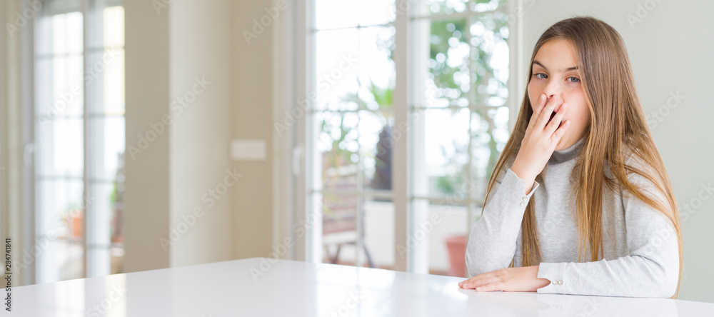 Wide angle picture of beautiful young girl kid wearing casual sweater bored yawning tired covering mouth with hand. Restless and sleepiness. Wide angle picture of beautiful young girl kid wearing casual sweater bored yawning tired covering mouth with hand. Restless and sleepiness.