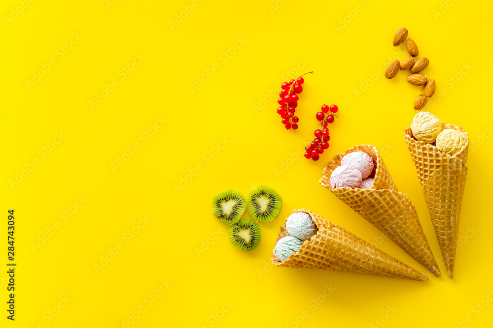summer dessert with ice cream in cones on yellow backgroung top view mockup