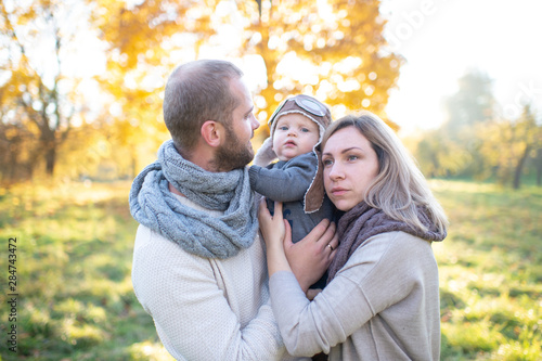 Happy family couple with child sincere emotions outdoor portrait. © benevolente