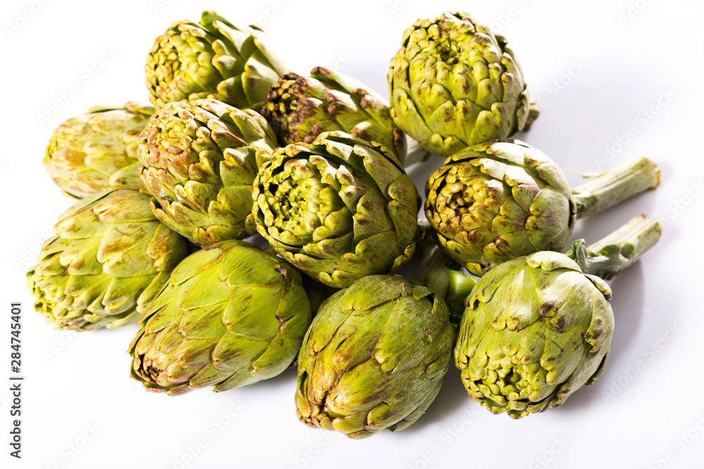 Obraz premium Uncooked green artichokes on a white surface