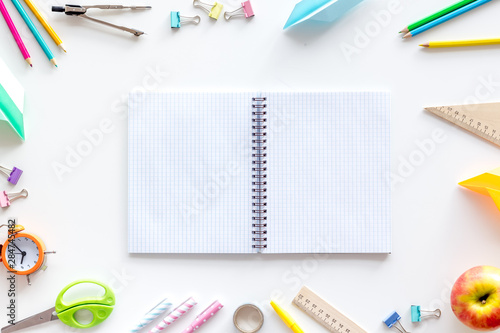 Student accessories frame around textbook on pupil's desk white background top view mockup