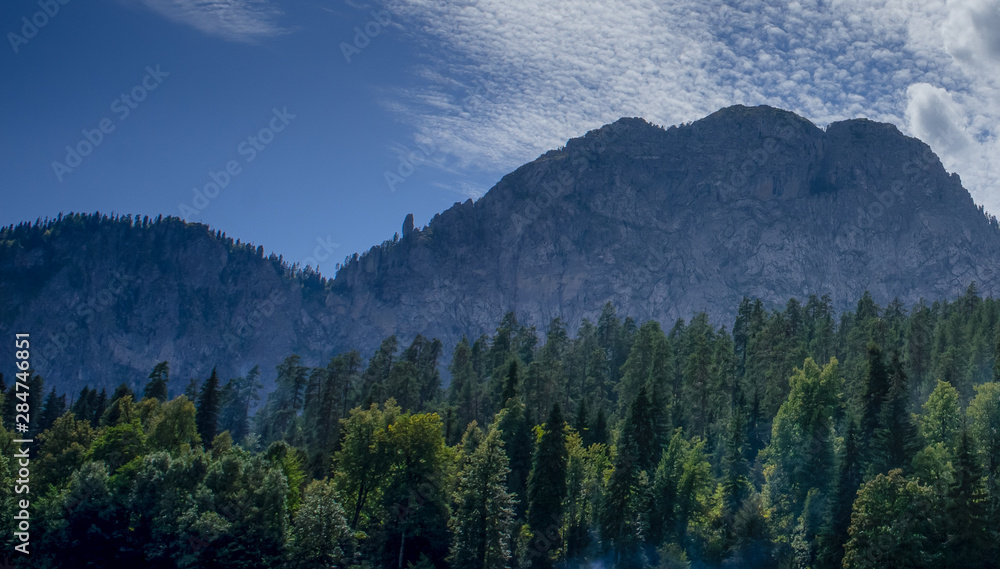 Natural landscape with mountains and forests against the sky.