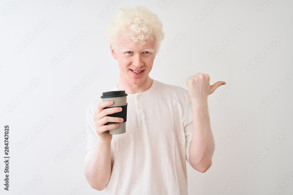 Young albino blond man drinking coffee standing over isolated white background pointing and showing with thumb up to the side with happy face smiling Young albino blond man drinking coffee standing over isolated white background pointing and showing with thumb up to the side with happy face smiling
