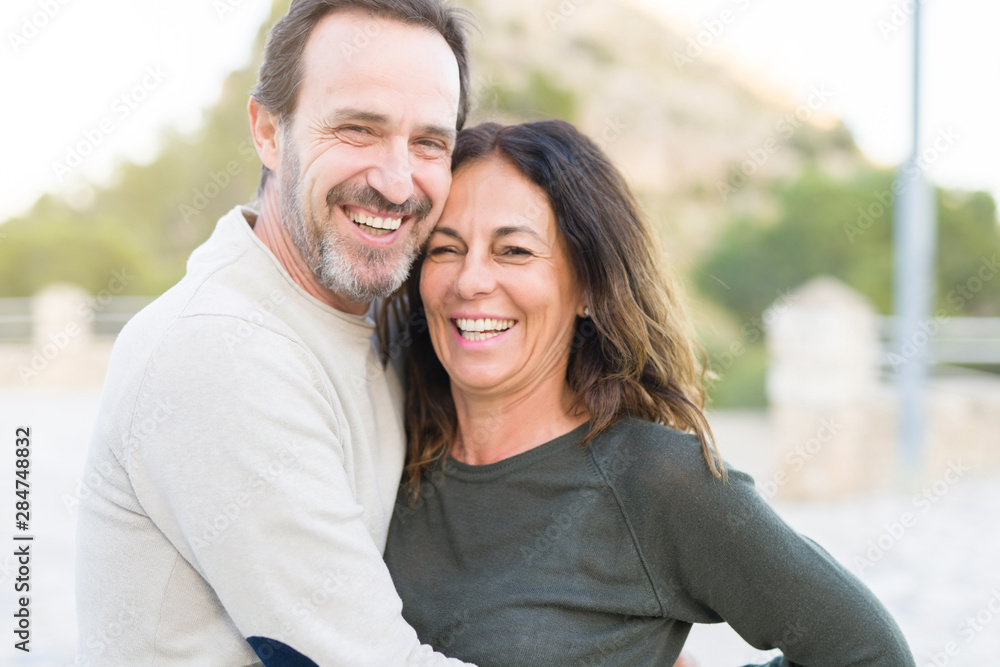 Romantic couple smiling and cuddling on a sunny day Romantic couple smiling and cuddling on a sunny day