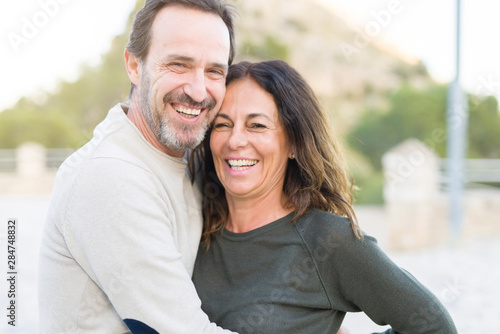 Romantic couple smiling and cuddling on a sunny day