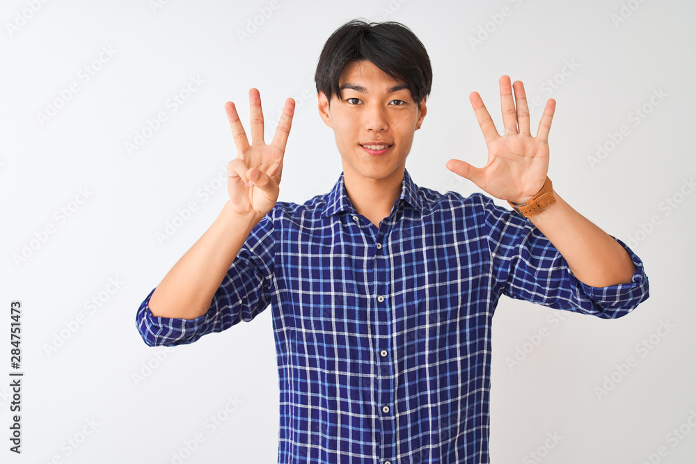 Young chinese man wearing casual blue shirt standing over isolated white background showing and pointing up with fingers number eight while smiling confident and happy. Young chinese man wearing casual blue shirt standing over isolated white background showing and pointing up with fingers number eight while smiling confident and happy.