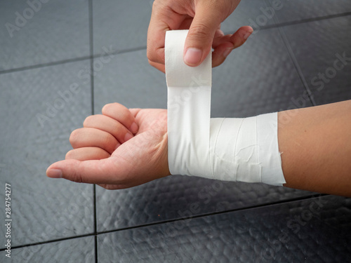 Black and white version of Athlete taping her wrist for injury and support  photo