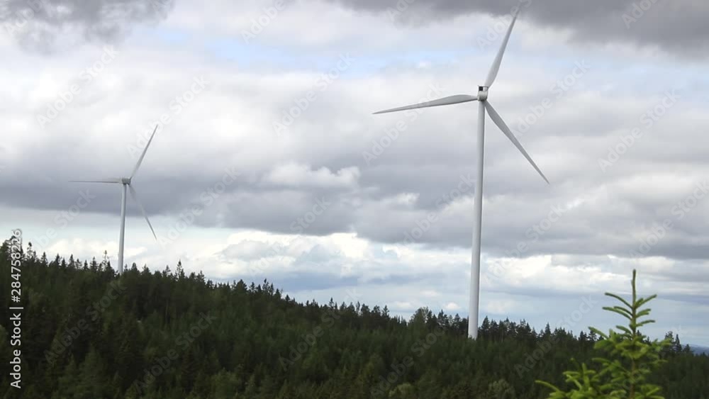 a dramatic pan shot with the windmills and the deep clouds. a dramatic pan shot with the windmills and the deep clouds.