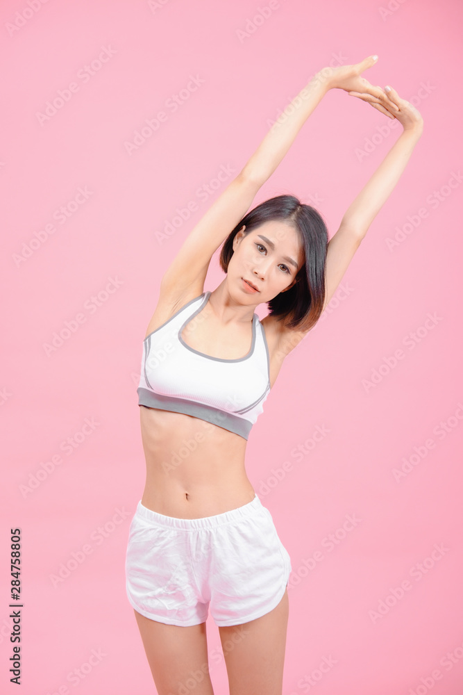 sport woman standing warm-up and stretch body before doing exercise on pink backgrounds, fitness concept, sport concept sport woman standing warm-up and stretch body before doing exercise on pink backgrounds, fitness concept, sport concept