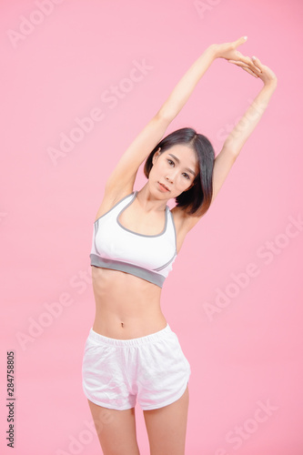 sport woman standing warm-up and stretch body before doing exercise on pink backgrounds, fitness concept, sport concept